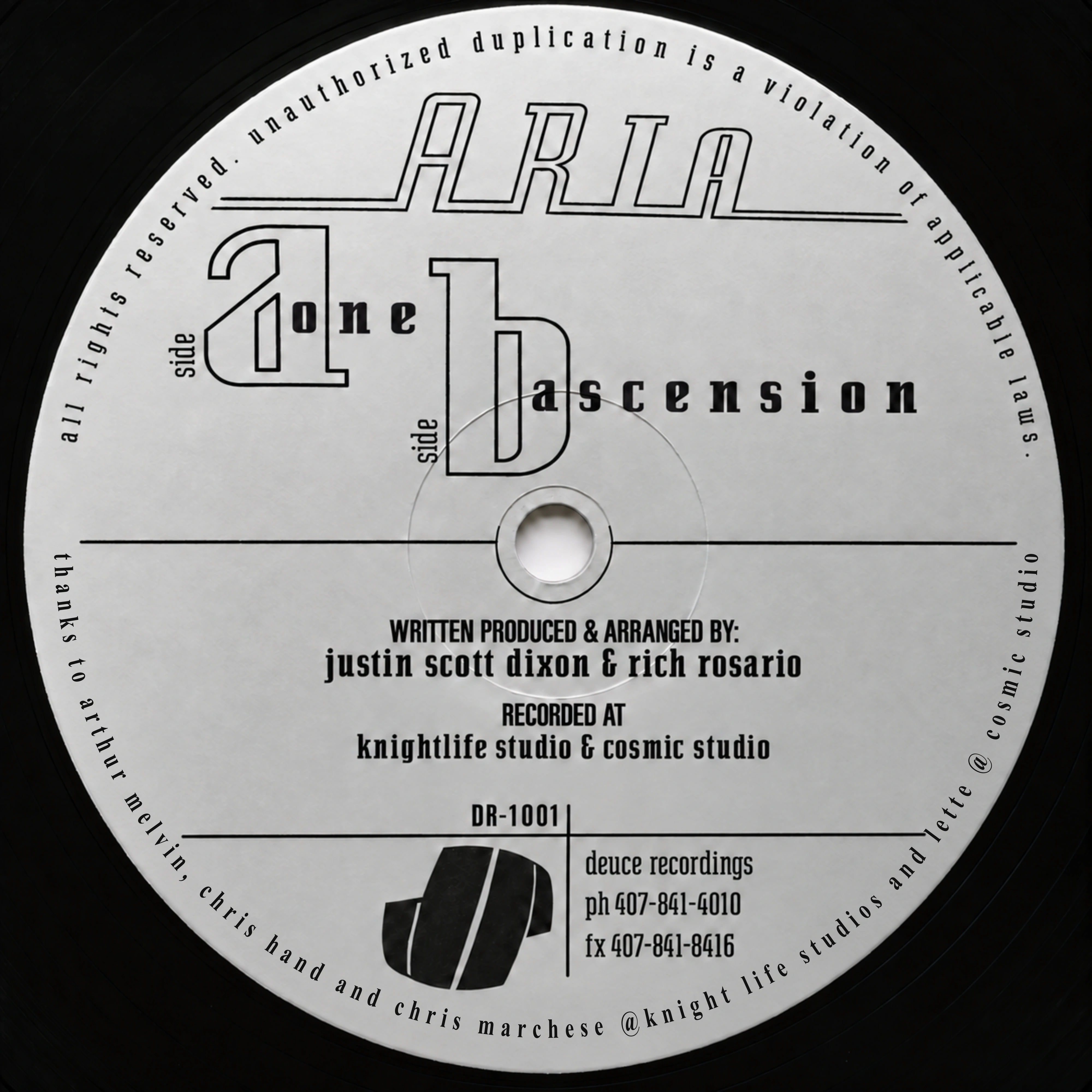 Restored silver-gray Aria One / Ascension DR-1001 label showing the track titles, shared writing, production and arrangement credits, and Deuce Recordings mark.